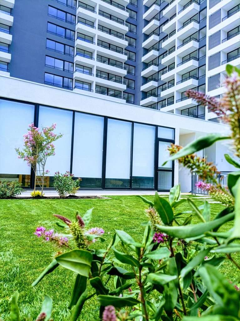 INICIO Áreas verdes y jardín de edificio residencial con césped y plantas ornamentales